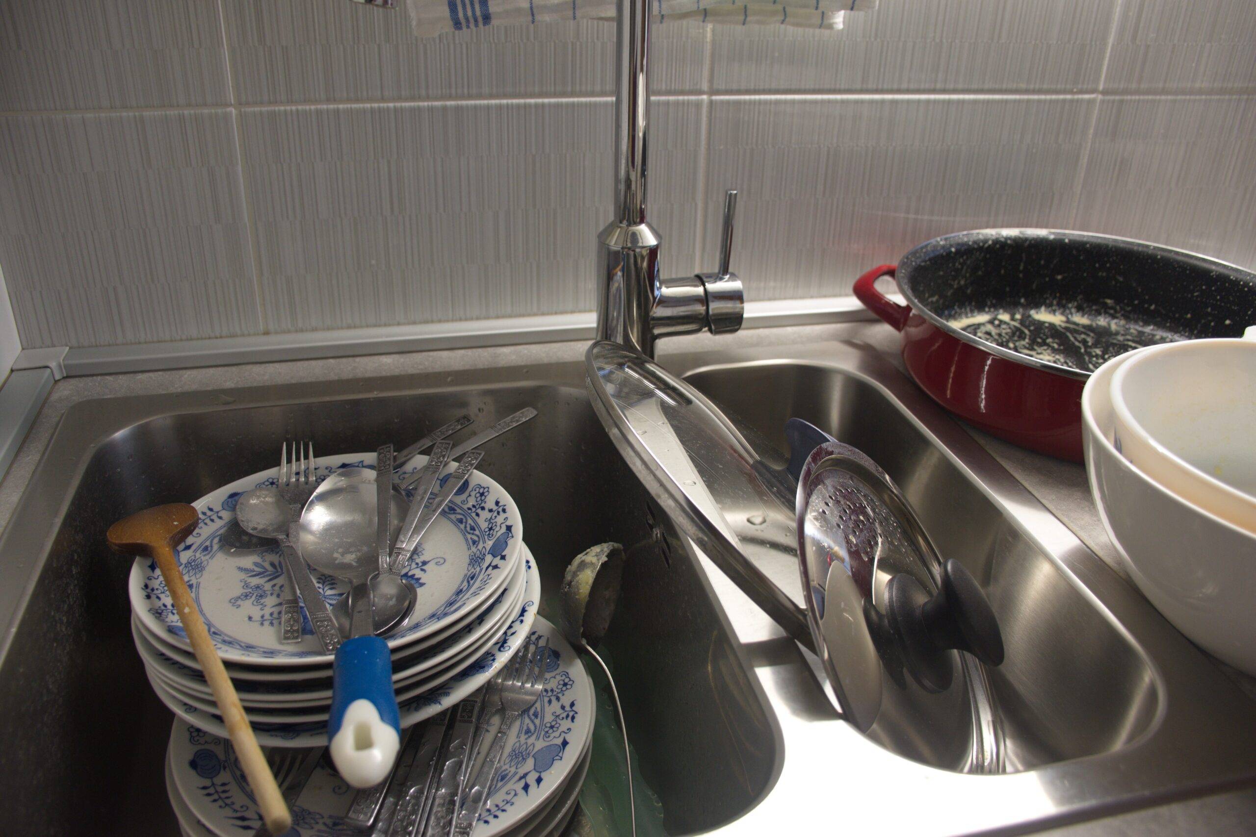 Stacks of dirty dishes in a sink.