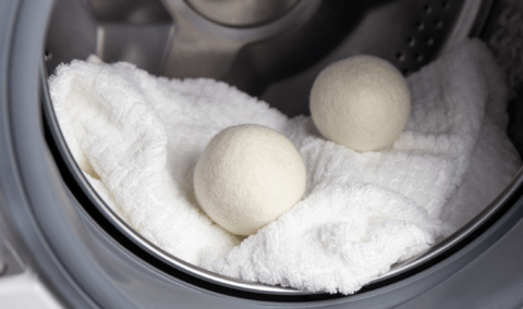Two dryer balls in a dryer with a blanket.