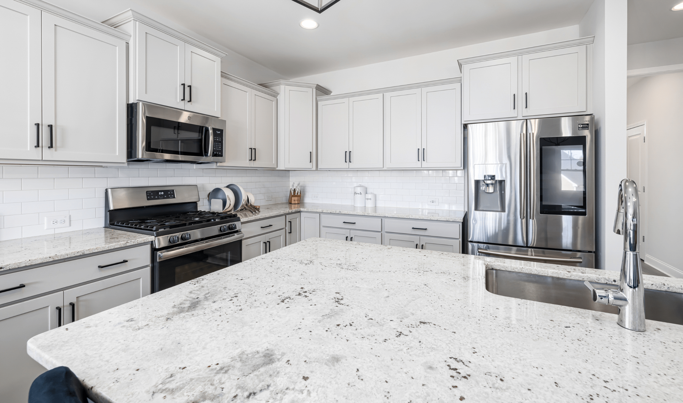A modern kitchen with marble counters.