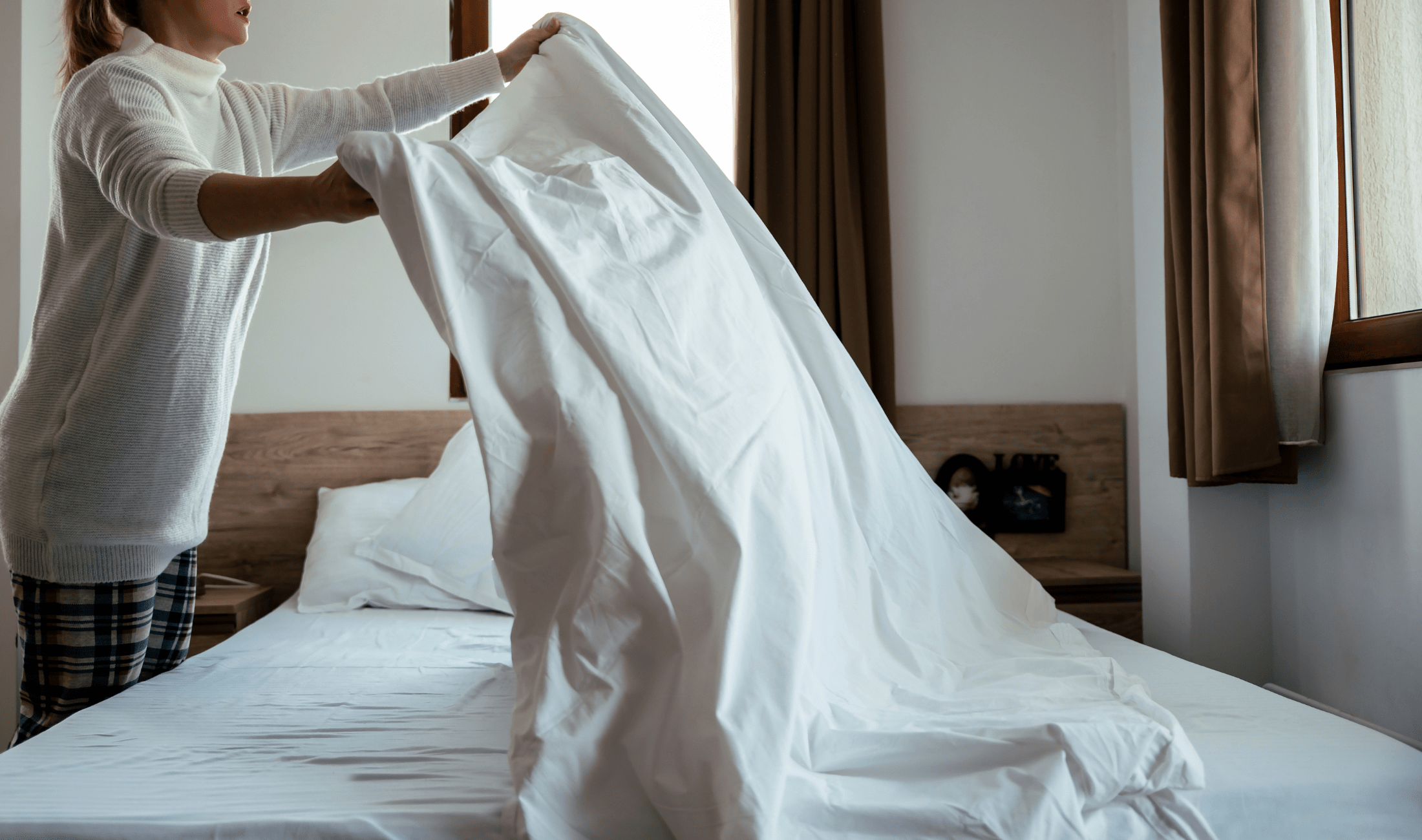 A person shaking out sheets.