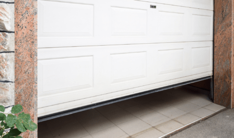 A white garage door slightly open.